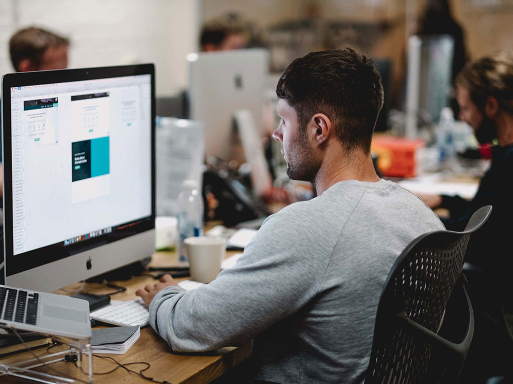 logo designer in front of imac and working on a color palette